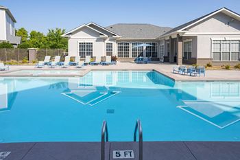 A swimming pool with a house in the background